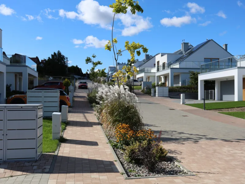 Woonerf w Brizo Park z nasadzeniami i domami po obu stronach